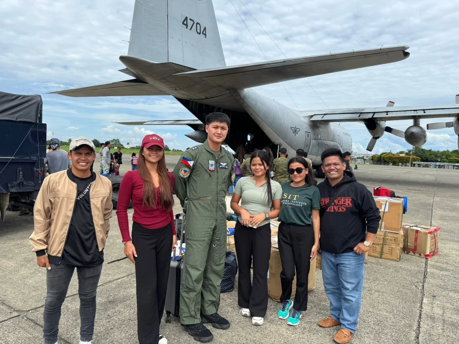 Ako Ang Saklay team members with relief supplies beside a cargo aircraft